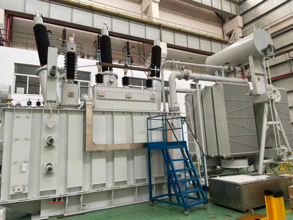Power Transformer Large oil-immersed power transformer assembly inside a manufacturing workshop